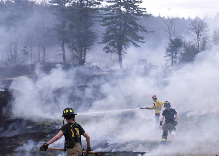 A fire at 100 Chase Farm Road in Hopkinton on Monday afternoon drew firefighters from around the area as flames spread from a garage to surrounding brush and fields.