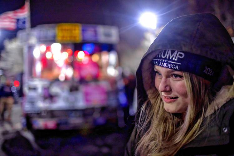 Kate Benner of Andover waits in line outside the Courtyard by Marriot in Concord to get in to see former President Donald Trump on Friday night.