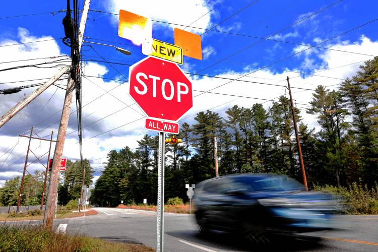 A SUV accelerates through the intersection of Mountain Road and Hoit Road after making a stop in the new all-way stop on Tuesday.