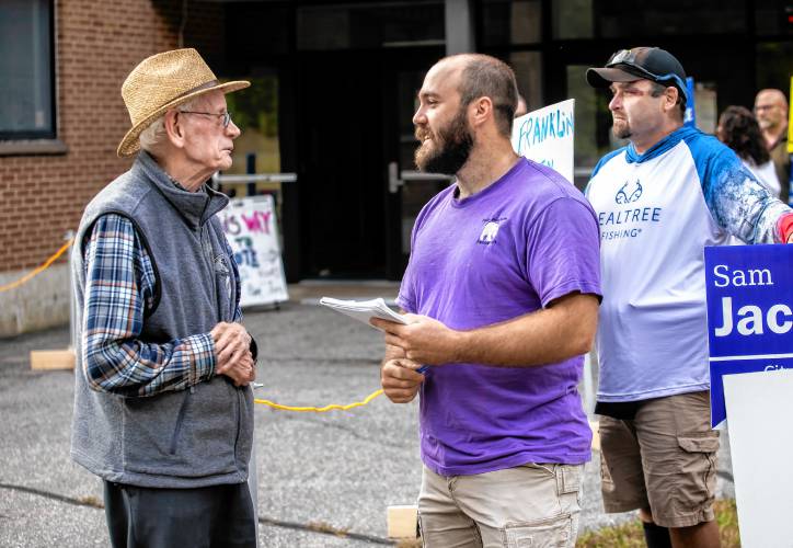 Sam Jacobson, running for Franklin city council in Ward 2, talks with voter Karl Grant, 87, after he voted at the Franklin High School on Tuesday, October 1, 2024.
