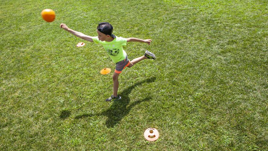 Leo McGinn tosses the ball during Jeti Dodgeball at the Concord Parks and Recreationâs Stay and Play Camp at Keach Park on Tuesday, July 26, 2022. The camps around the city will extended a week into August.