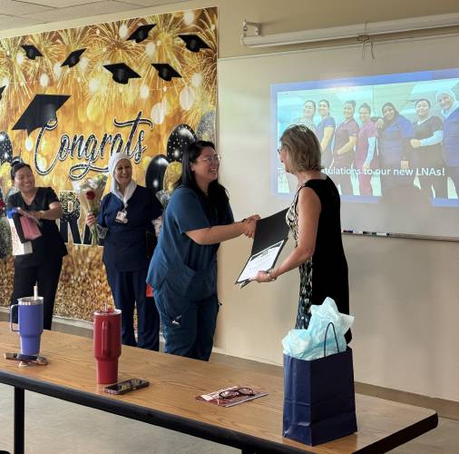 Yuhsien Wu-Riggs recieves her LNA certification at the Second Start LNA program graduation at NHTI on Friday. 