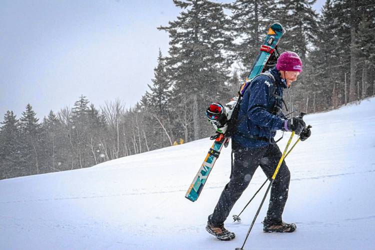General manager Tom Day walks up the slope at Gunstock Mountain Resort with his skis. 