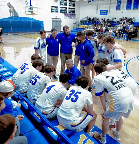 Nate Camp (center) talks with his starters before a game this season at Kearsarge Regional High School. Feb. 5, 2024.