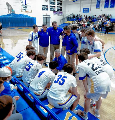 Kearsarge boys’ basketball coach Nate Camp (center) talks with his starters before a game this season at Kearsarge Regional High School in North Sutton.