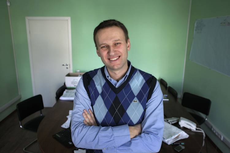 FILE - Russian opposition leader Alexei Navalny waves from his office window in Moscow, Russia on April 1, 2010. Alexei Navalny, the fiercest foe of Russian President Vladimir Putin who crusaded against official corruption and staged massive anti-Kremlin protests, died in prison Friday Feb. 16, 2024 Russia’s prison agency said. He was 47. (AP Photo/Alexander Zemlianichenko, File)