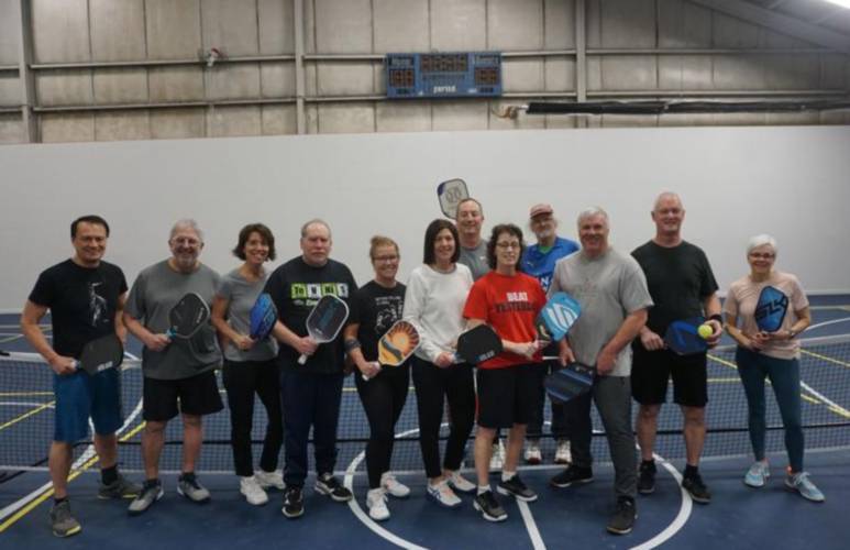  Nancy Morton, center in red, meets a group at Gilford Hills Tennis & Fitness Club regularly to play pickleball, a sport similar to tennis played with a wiffleball.