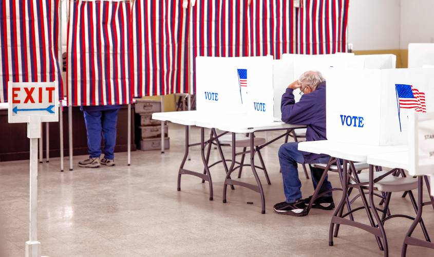 Stephen Tierney studies the ballot as he votes at the St. John’s Parish Hall in Allenstown during voting on Tuesday.