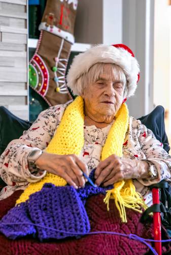 Lucienne Boisvert uses her fingers to guide her crochet hook as she works on one of her creations at Peabody Place in Franklin on Tuesday, December 24, 2024. Boisvert, who has been blind for the past fifteen years, crochets daily. In that time, she has donated over 2000 scarves and $4000 to homeless shelters and low income families thanks to a partnership with the Meredith Village Savings Bank.