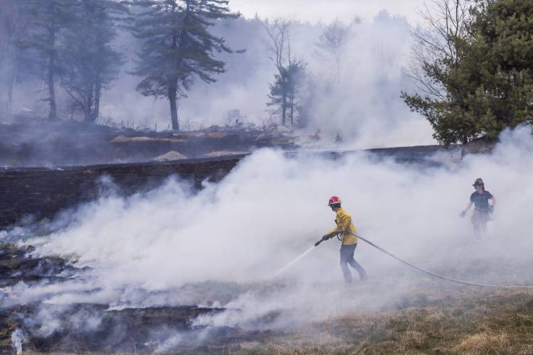 A fire at 100 Chase Farm Road in Hopkinton on Monday afternoon drew firefighters from around the area as flames spread from a garage to surrounding brush and fields.