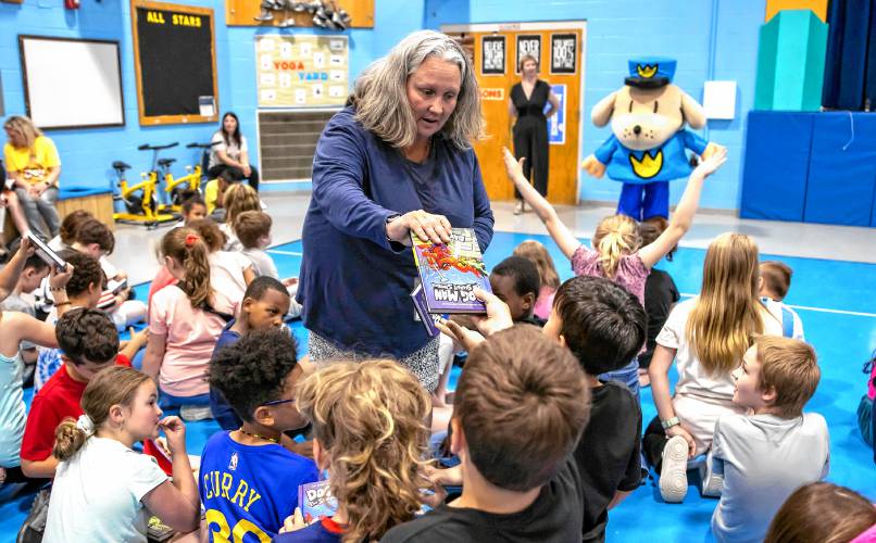 Third grade teacher Michele Cernuda passes out Dav Pilkey’s latest book, Dog Man: the Scarlet Shedder to her students at Beaver Meadow School on Monday.