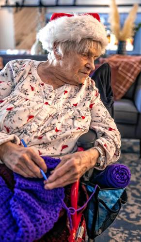 Lucienne Boisvert uses her fingers to guide her crochet hook as she works on one of her creations at Peabody Place in Franklin on Tuesday, December 24, 2024. Boisvert, who has been blind for the past fifteen years, crochets daily. In that time, she has donated over 2000 scarves and $4000 to homeless shelters and low income families thanks to a partnership with the Meredith Village Savings Bank.