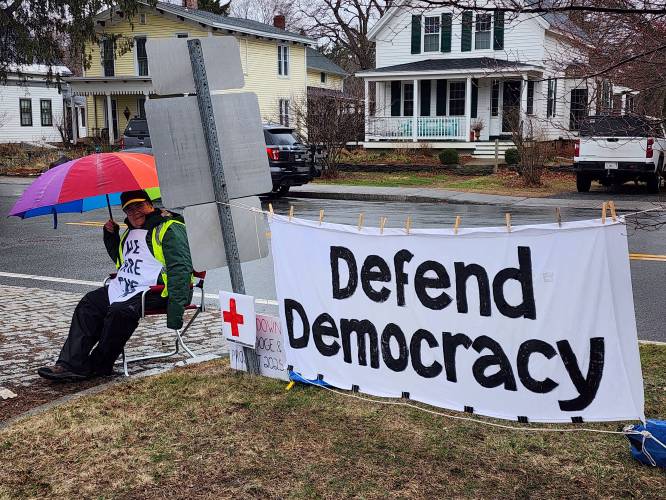 Conway resident Mary McClintock with a “Defend Democracy” banner made by Ann Gibson during Saturday’s “Hands Off!” protest along Route 116. Conway resident Mary McClintock with a “Defend Democracy” banner made by Ann Gibson during Saturday’s “Hands Off!” protest along Route 116.