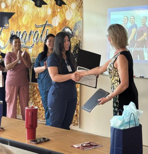 Lilian Gomez recieves her LNA certification at the Second Start LNA program graduation at NHTI on Friday. 