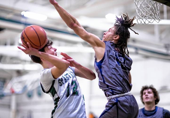 Pembroke guard Colin Dube (12) goes up against MV forward Nic Oglesby during the first half. Dube drew a foul and completed a three-point play.