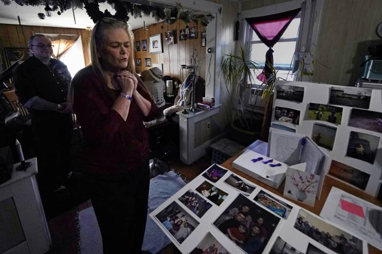 Trina Cotter clutches a pendant containing some of the ashes of her son, Zach Robinson, during an interview at their family home, Thursday, Nov. 30, 2023, in Dover, N.H. Robinson spent decades trying to fight off nightmares about being raped as a child at New Hampshire’s youth detention center. He died last in November, still waiting for accountability for his alleged abusers. (AP Photo/Charles Krupa)