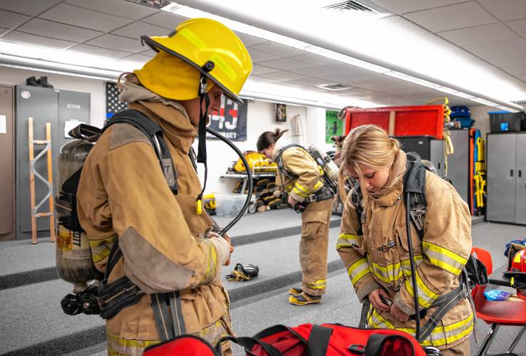 CRTC firefighter students Adyson Lamb, left, and Lillian O’Hara put on their suits before working through an obstacle course on Thursday at Concord High School.