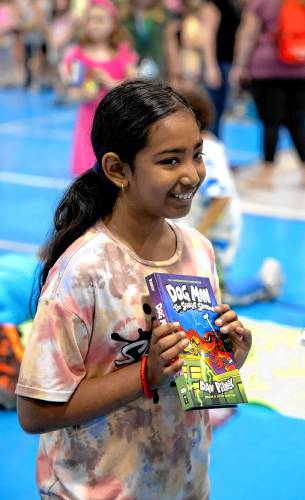 Third grader Sophia Das holds up Dav Pilkey’s latest book, Dog Man: the Scarlet Shedder at Beaver Meadow School on Monday, June 10, 2024.