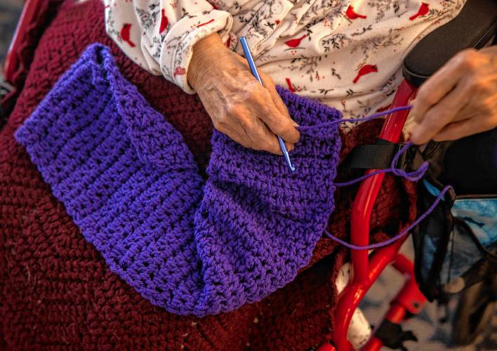Lucienne Boisvert uses her fingers to guide her crochet hook as she works on one of her creations at Peabody Place in Franklin on Tuesday, December 24, 2024.