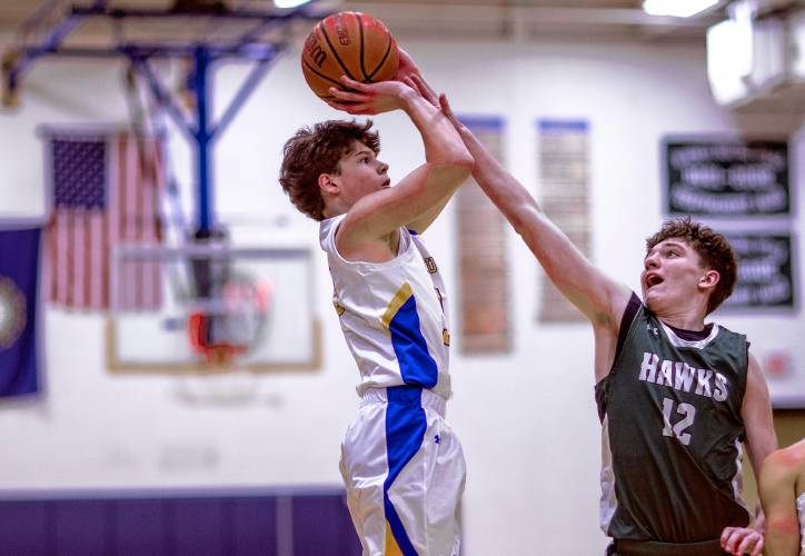 Kearsarge guard Eli Whipple shoots over Hopkinton forward Tommy Dwyer during the first half of Tuesday’s win.