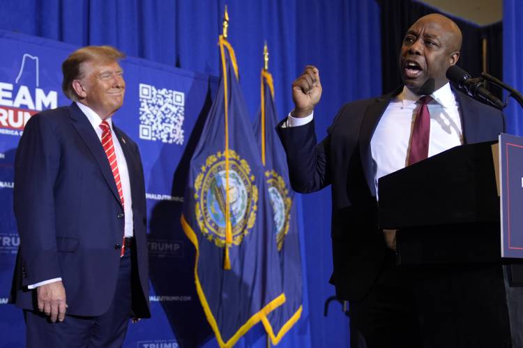 Sen. Tim Scott, R-S.C., speaks as Republican presidential candidate former President Donald Trump listens at a campaign event in Concord on Friday.