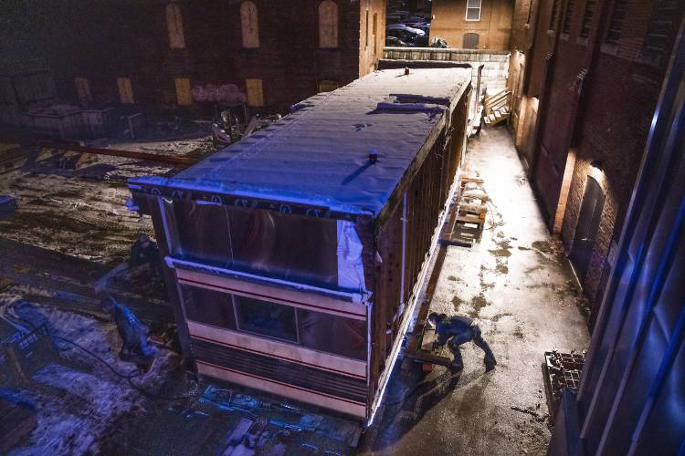 Geddes Building Mover worker attaches an air compressor to elevate the bladder to lift up the 1942 Silk City Diner kitchen to move it into place in Artist Alley on Tuesday evening, December 10, 2024.