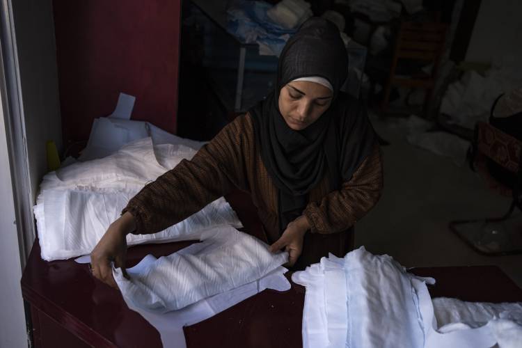 A Palestinian woman sews diapers in Rafah, southern Gaza Strip, Thursday, Feb. 15. Palestinians in Gaza have experienced severe shortages of basic necessities since the war began.