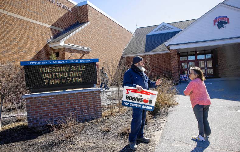 Dawn Mistler listens to Pittsfield school board candidate Tim Robinson outside the middle high school on Tuesday, March 12, 2024.