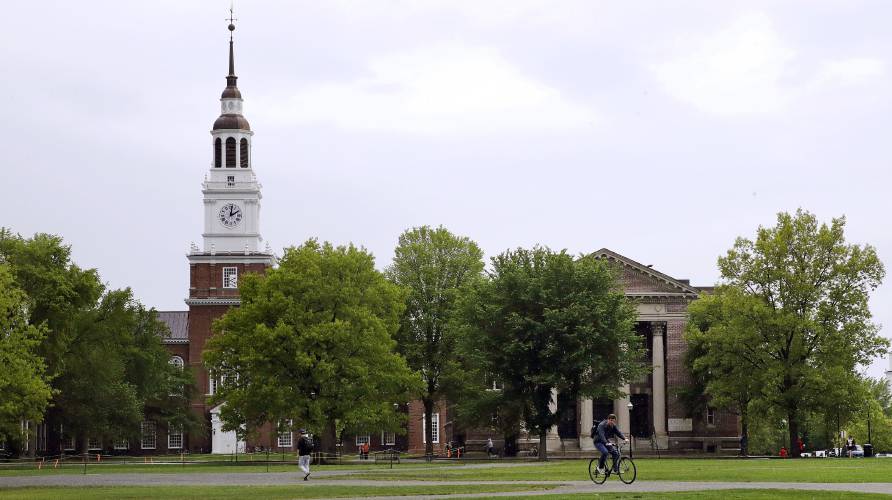 In this May 22, 2018 file photo, students cross The Green in front of the Baker-Berry Library at Dartmouth College in Hanover, N.H. 