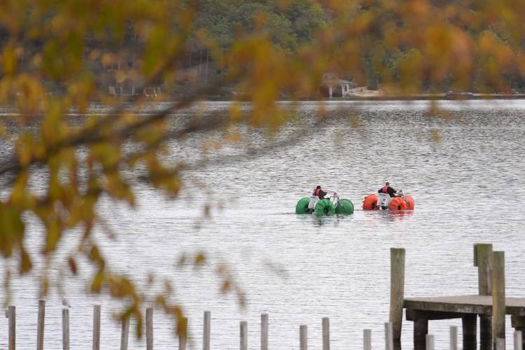 Leaves on trees display bright colors as people using water craft float on Meredith Bay, in Meredith, N.H., Wednesday, Oct. 2, 2024. (AP Photo/Steven Senne)