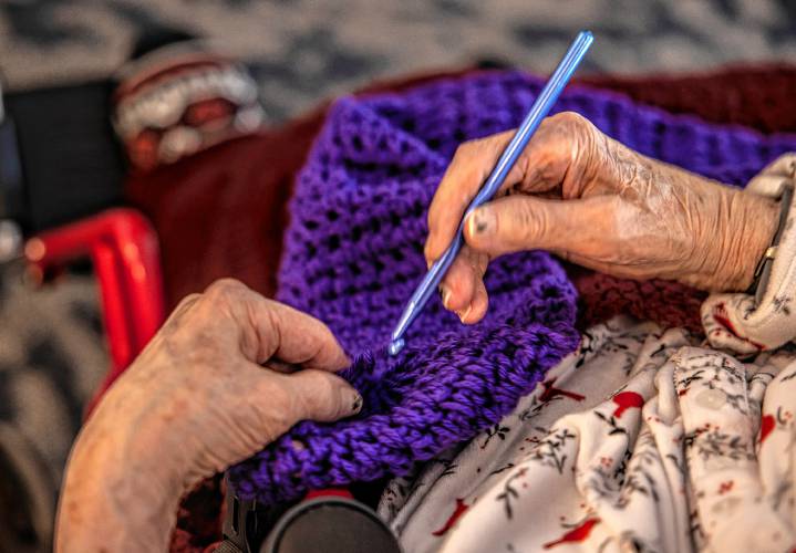 Lucienne Boisvert uses her fingers to guide her crochet hook as she works on one of her creations at Peabody Place in Franklin on Tuesday, December 24, 2024.