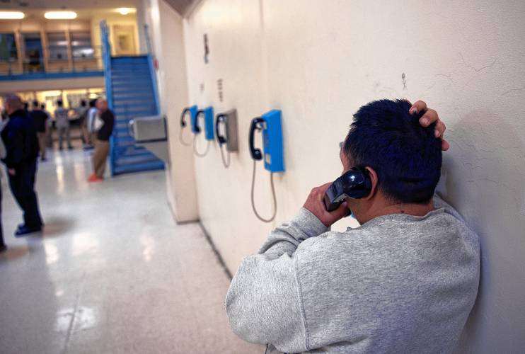 An inmate uses a phone in one of the units with a high percentage of inmates brought in by U.S. Immigrations and Customs Enforcement.