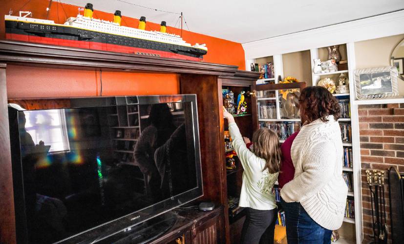 As a family, the Sheaffs like to build Legos. Nicole Sheaff’s youngest daughter takes one out of the collection on display in their Exeter living room.