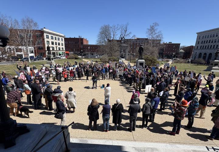 Rally goers form a circle as they protest the proposed Republican budget at the State House on Wednesday, April 9, 2025.