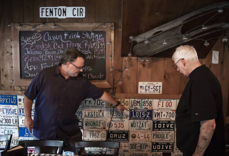 Peter Fenton Jr., and Peter ‘Big Pete’ Fenton Sr. show the old license plates in the main room of the Appleseed Restaurant in Bradford which has been a staple in the community for the last 48 years.