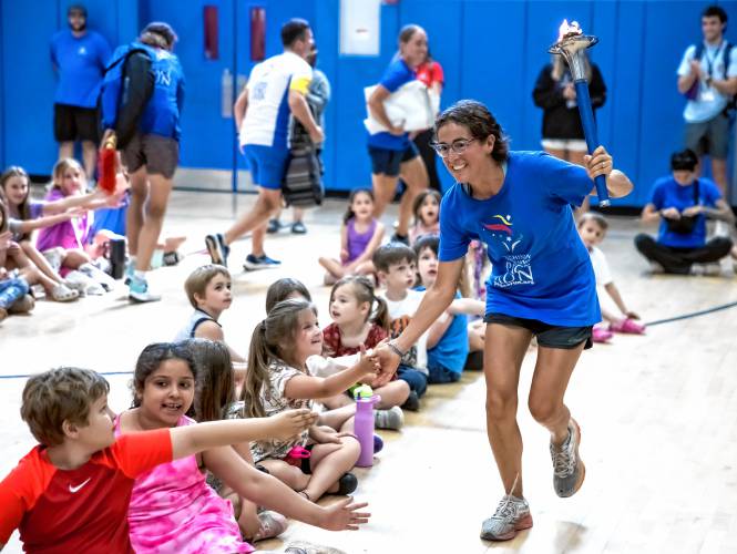 Nayajay Perugini from Italy greets the children of the Boys and Girls Club as the runners come into the gymnasium for a ceremony detailing their mission before heading out to Boston on Tuesday.