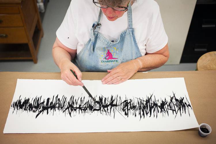 Adele Sanborn works on an ink accordion book in her new studio space, Cornerstone Design at Twiggs Gallery, in Boscawen in 2015.