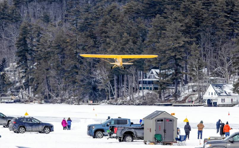 Visitors watch a plane takes off at the Alton Bay airstrip on Sunday, February 2, 2025. The ice must be at least a foot thick on Lake Winnipesaukee at the bay and the runway is a minimum of 2, 600 feet long and at least 100 feet wide.