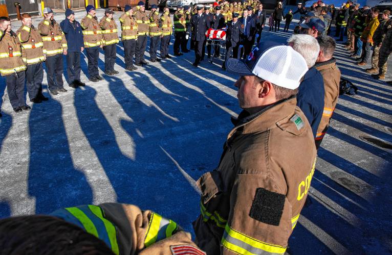 Firefighters from around the region salute as a color guard brings out Christopher Girard from the Medical Examimerâs office at Concord Hospital on Monday, March 3, 2025. Girard died last weekend after a brief illness.