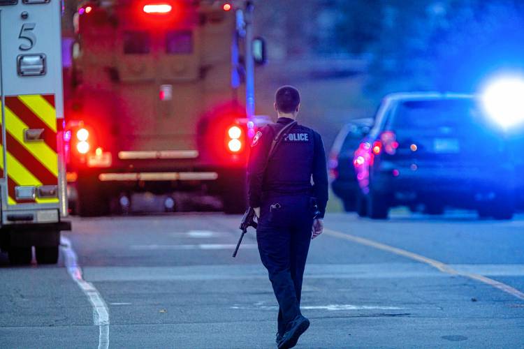 A Concord police officer walks outside the New Hampshire Hospital grounds after a shooting at the facility on Friday afternoon, November 17, 2023.
