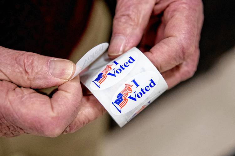 An election worker holds a roll of 