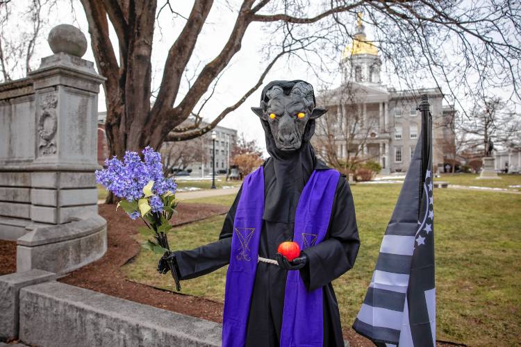 The Satanic Temple's holiday display has returned to its place outside the New Hampshire State House on Monday after it was vandalized a week ago.