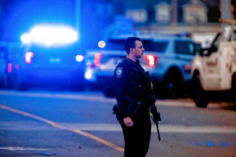 A Concord police officer walks outside the New Hampshire Hospital grounds after a shooting at the facility on Friday afternoon, November 17, 2023.