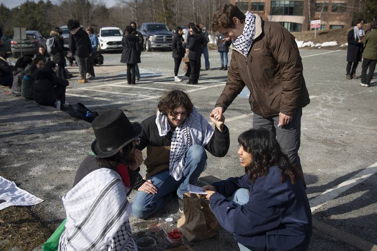 Dartmouth freshman Ben, top right, who declined to give his last name, shakes hands with sophomore Ramsey Alsheikh, center, president of the Palestine Solidarity Coalition, while he and junior Jordan Narrol, left, end their eight-day hunger strike during a protest outside  Lebanon District Court in Lebanon on Monday.
