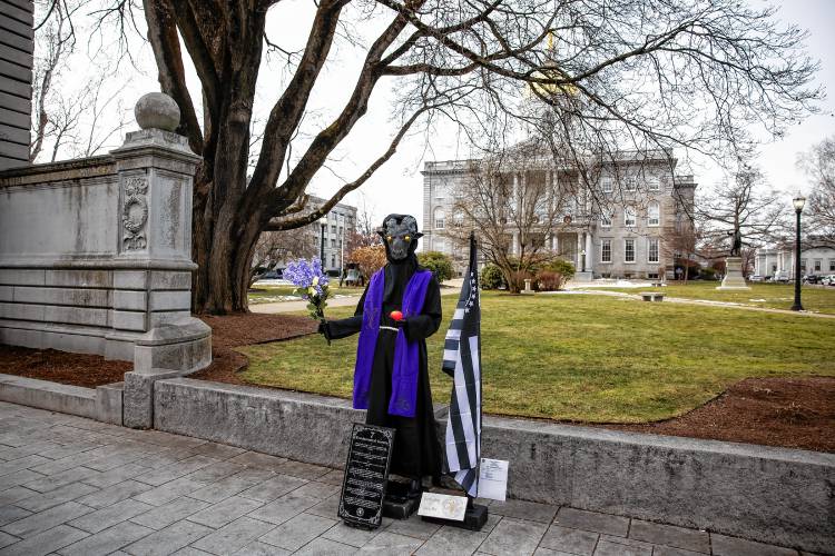 The Satanic Temple's holiday display has returned to its place outside the New Hampshire State House on Monday after it was vandalized a week ago.