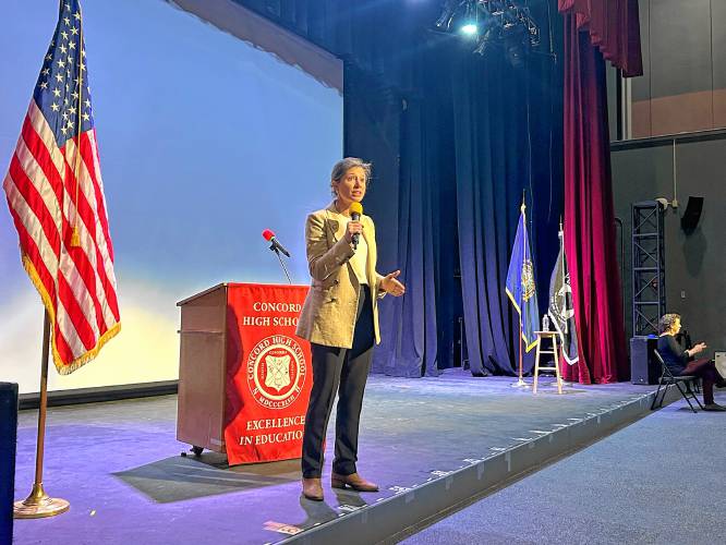 Congresswoman Maggie Goodlander speaks on stage at Concord High School’s auditorium.