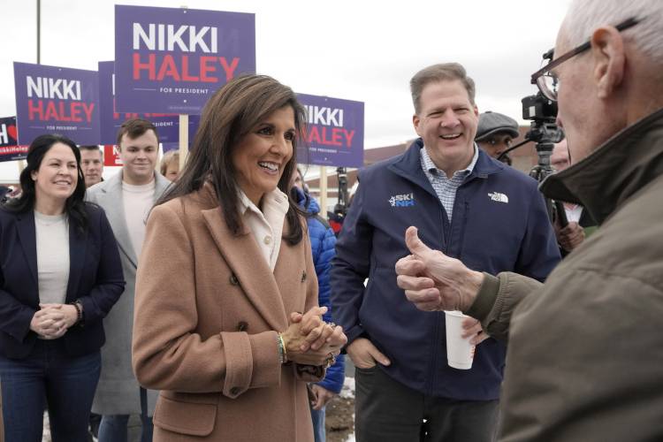 Republican presidential candidate former U.N. Ambassador Nikki Haley, center left, and N.H. Gov. Chris Sununu, center right, greet people, Tuesday, Jan. 23, 2024, near a polling site at Winnacunnet High School in Hampton, N.H. (AP Photo/Steven Senne)