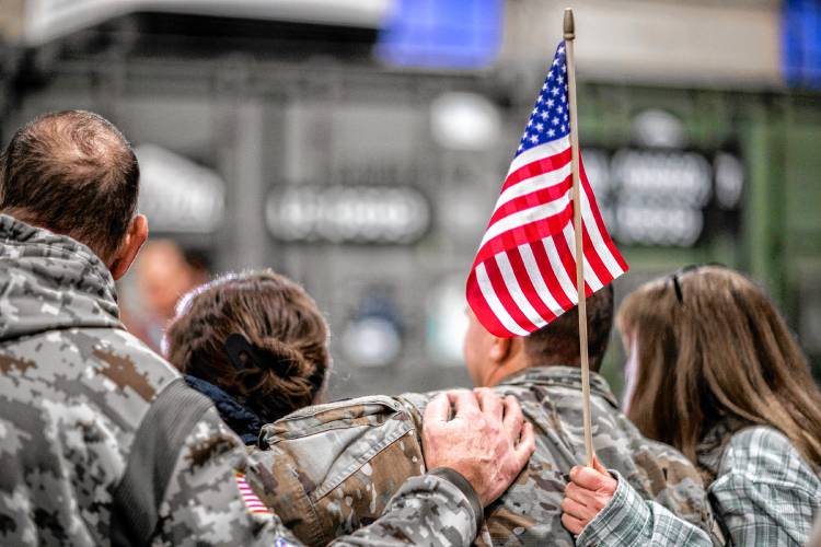 Members of the New Hampshire Army National Guard  3rd Battalion, 197th Field Artillery Regiment, back from 10-month deployment to the Middle East  take photos on their arrival at the Manchester Armory on Thursday night, February 8, 2024.