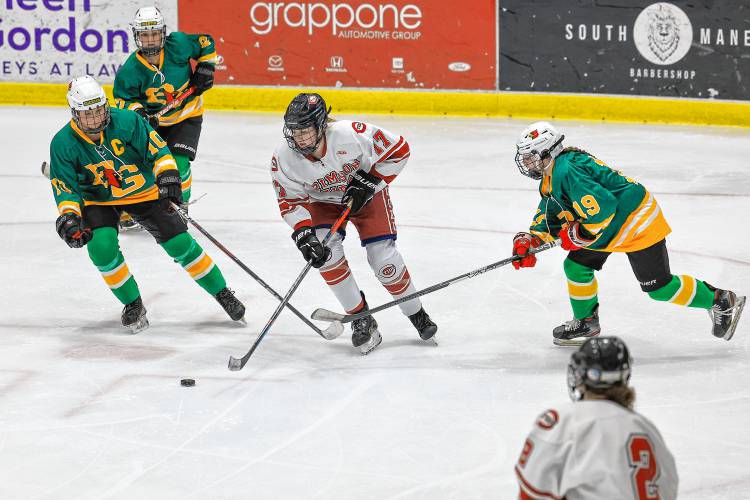 Concord’s Caroline Fortin (17) attempts to handle the puck as Bishop Guertin defenders close in at Everett Arena on Wednesday. Concord closed out the regular season with a 2-0 loss.