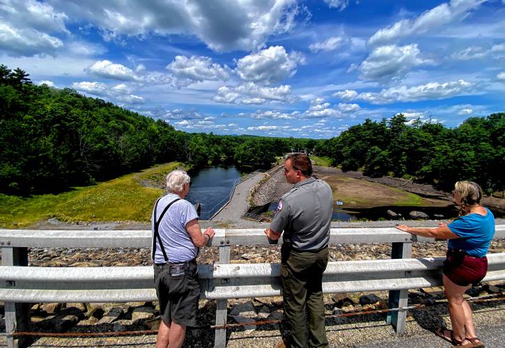 Park Ranger Dan Orlando, center, points out the features of the spillway atop the Hopkinton Dam on Route 127 in Contoocook during the tour of the Gatehouse area on July 20.